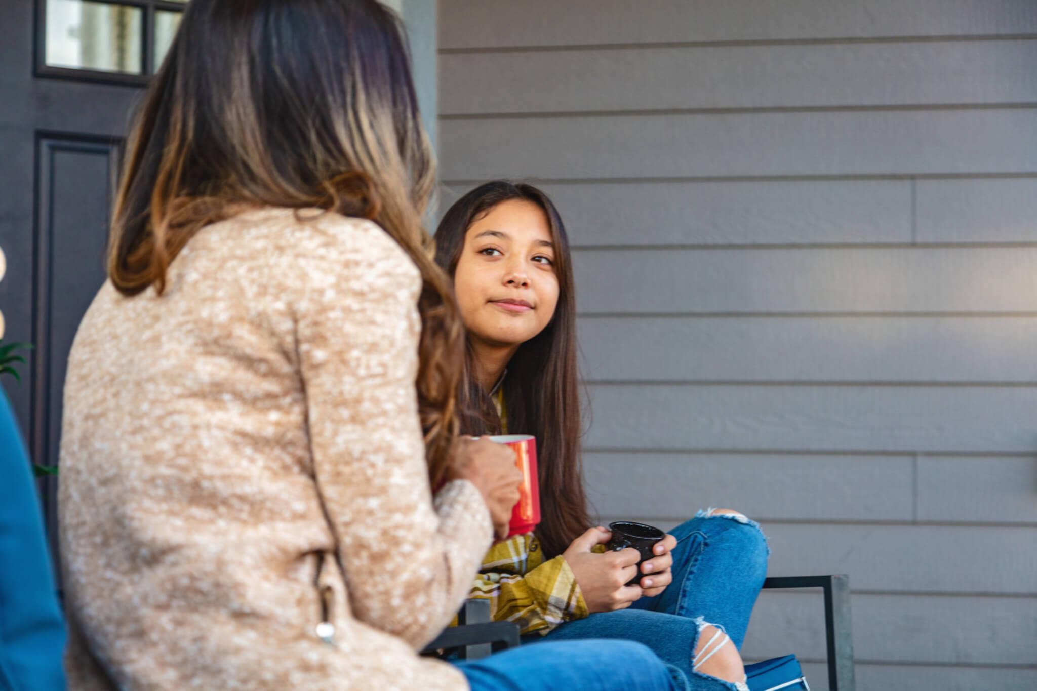 A woman talks with a young multiracial child in an office.